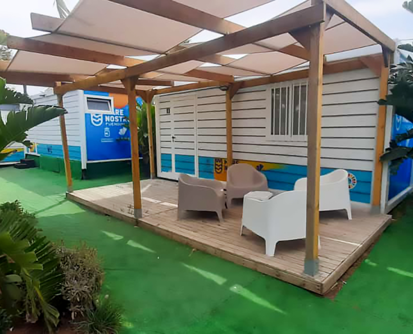 Módulo prefabricado de Europa Prefabri con revestimientos personalizados, opciones de acabado en superficies gofradas, acanaladas y lisas, y vinilos exteriores con colores corporativos y logotipos. Diseño adaptable con pintura en diversos colores, peto perimetral y estructura oculta para un acabado moderno y profesional.