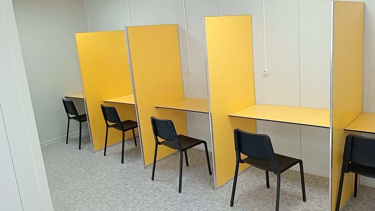"Conjunto modular en Cañada Real destinado a un centro de ayuda a la drogadicción, con sala de venopunción y espacios adaptados para atención sanitaria."